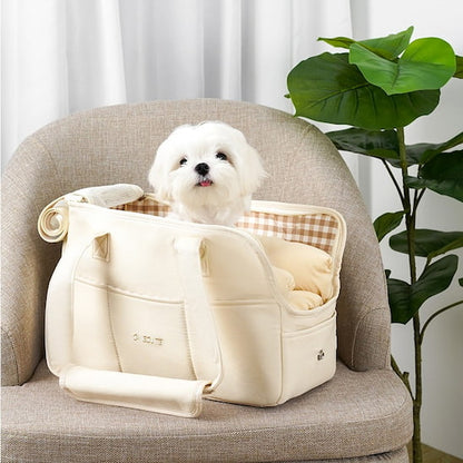 chien blanc dans sac de transport pour chien sur fauteuil